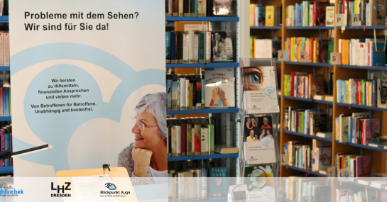 Zu sehen sind Bücherregale in der Brigitte-Reimann-Stadtbibliothek Hoyerswerda und ein Aufsteller von Blickpunkt Auge mit der Aufschrift "Probleme beim Sehen? Wir sind für Sie da! Wir beraten zu Hilfsmitteln, finanziellen Ansprüchen und vielem mehr. Von Betroffenen für Betroffene. Unabhängig und kostenfrei."