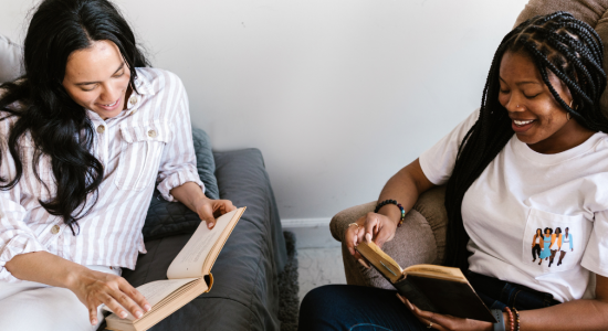 Zwei Frauen lesen zusammen.