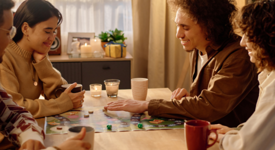 Vier Personen spielen ein Brettspiel.