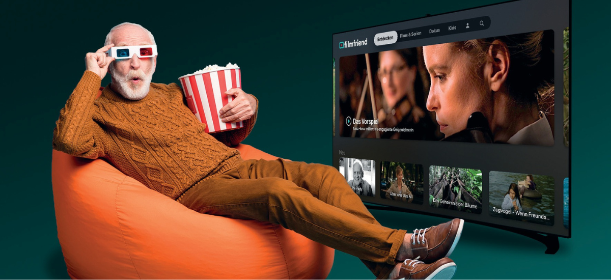 Älterer Mann sitzt in einem Sitzsack mit 3D-Brille und Popcorn und schaut fensehen