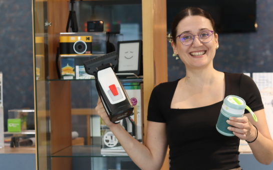 Maja Kos präsentiert die Bibliothek der Dinge der Brigitte-Reimann-Stadtbibliothek Hoyerswerda. In den Händen hält sie einen Fenstersauger und eine Galakto-Box.